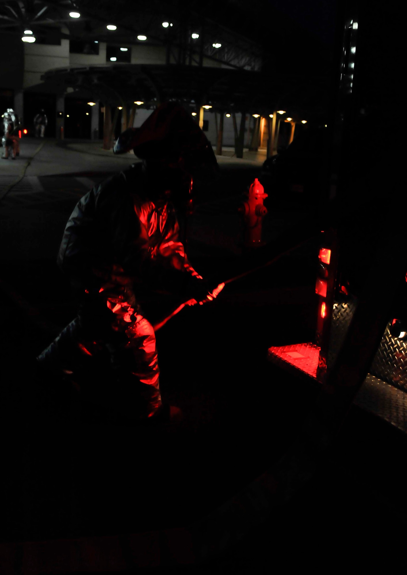 A firefighter pulls part of a hose off the fire truck after arriving on scene May 6 during a simulated missile attack scenario at the base passenger terminal on Osan Air Base, Republic of Korea. The scenario caused a fire in the building and turned into a mass casualty event. (U.S. Air Force photo by Senior Airman David Owsianka)