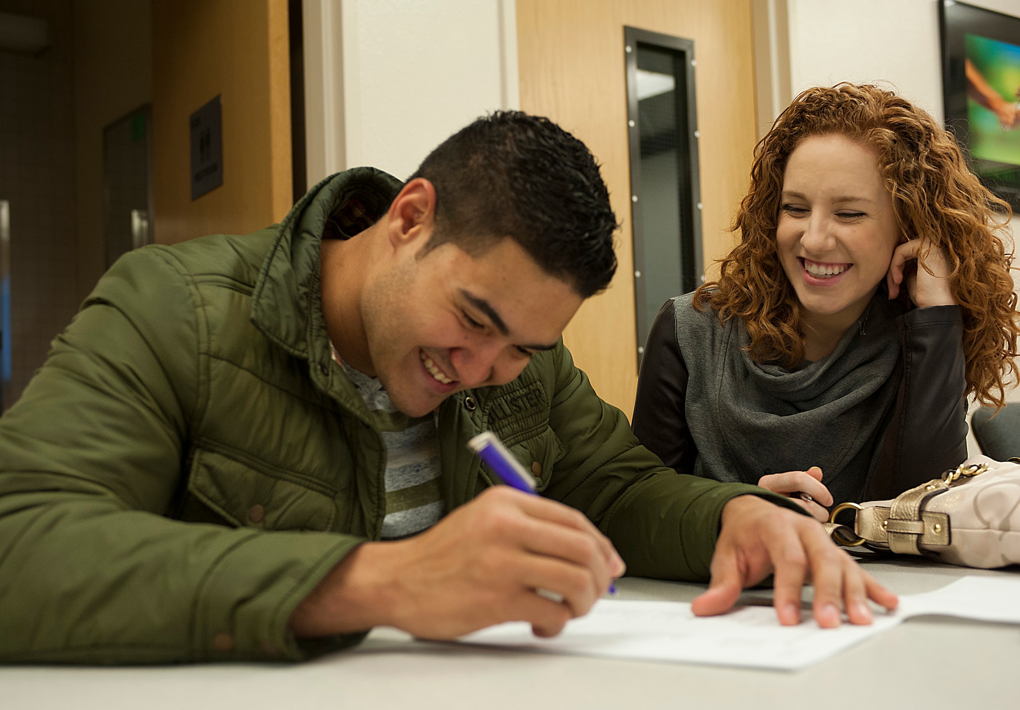 Staff Sgt. Ross Escobar, 5th Aircraft Maintenance Squadron weapons load crew team chief, and his wife Kami Alise, fill out paper work during an Obstetrics orientation at Minot Air Force Base, N.D., May 2, 2014. Escobar and his wife are expecting to welcome their new baby in October, and attended the orientation in order to learn how to have the safest and easiest pregnancy possible. (U.S. Air Force photo/Senior Airman Stephanie Sauberan)