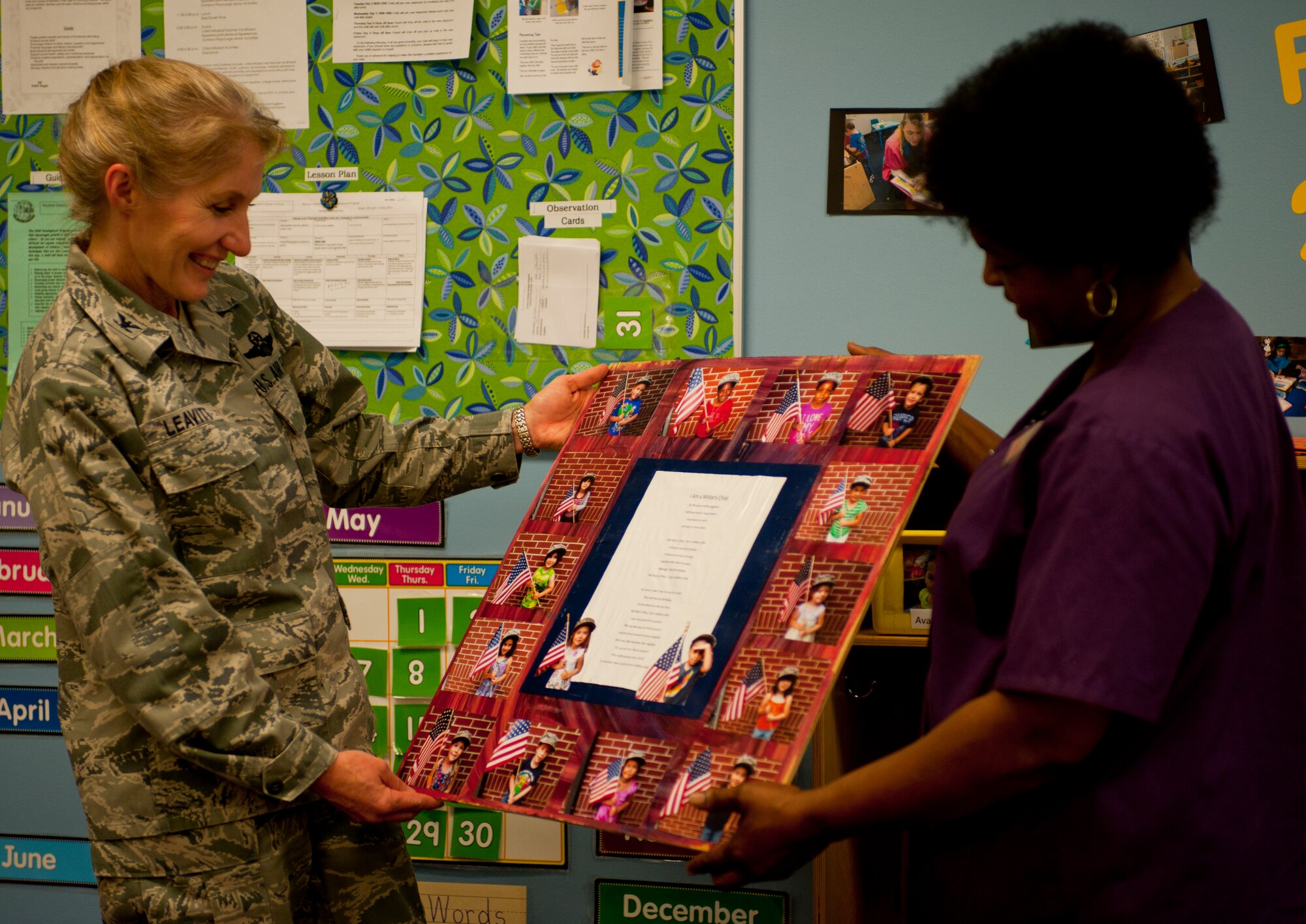 Betty Hinnant, Child Development Center child and youth program assistant, presents Col. Jeannie Leavitt, 4th Fighter Wing commander, with a mural and thank you letter on behalf of the Child Development Center’s preschool class May 2, 2014, at Seymour Johnson Air Force Base, N.C., in appreciation for her participation in Child Abuse Prevention Month. The mural featured pictures of every student in the class to remind Leavitt of the children she impacted during the past month. (U.S. Air Force photo by Staff Sgt. Michael Charles)