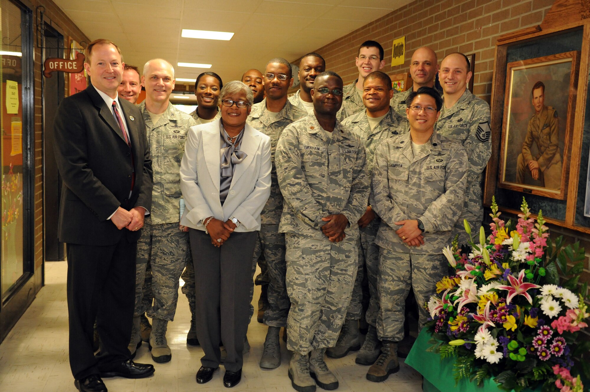Members of the 844th and 744th Communication Squadrons pose with Dr. Deborah Stone (center left), Francis T. Evans Elementary School principal, for a photo in front of a memorial display case in Clinton, Md., May 2, 2014. The case displays memorabilia of the school’s namesake, Capt. Francis T. Evans, Jr. and is located at the school just outside of Joint Base Andrews, Md. (U.S. Air Force photo/Aimee Fujikawa)