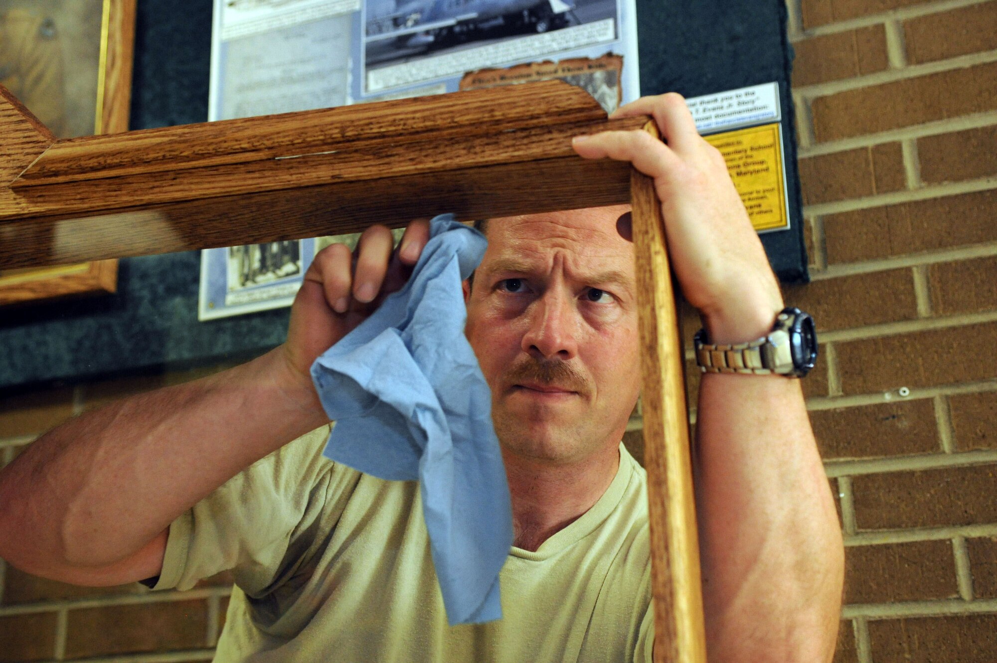 Master Sgt. Matt Cagle, 744th Communication Squadron plans and program manager, makes the final touches on a memorial display case before mounting it at the Francis T. Evans Elementary School May 1, 2014. The case displays memorabilia of the school’s namesake, Capt. Francis T. Evans, Jr. and is located at the school just outside of Joint Base Andrews, Md. (U.S. Air Force photo/Aimee Fujikawa)