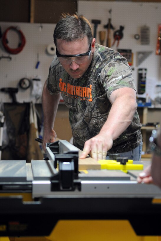 Master Sgt. Matt Cagle, 744th Communication Squadron plans and program manager, saws the first piece of oak for a display case frame at his home workshop in Clinton, Md., April 22, 2014. The case displays memorabilia of the school’s namesake, Capt. Francis T. Evans, Jr. and is located at the school just outside of Joint Base Andrews, Md. (U.S. Air Force photo/Aimee Fujikawa)