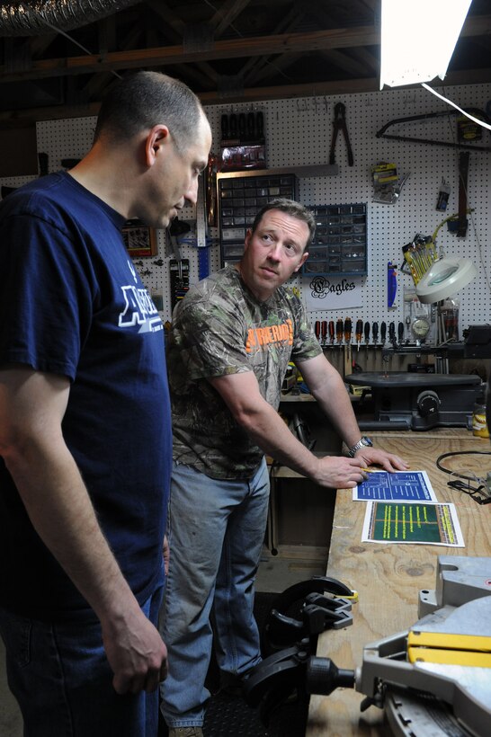 Master Sgts. Phillip Allen and Matt Cagle, 744th Communication Squadron plans and program managers, look over design plans before constructing a memorial display case at Cagle’s home workshop in Clinton, Md., April 22, 2014. The case displays memorabilia of the school’s namesake, Capt. Francis T. Evans, Jr. and is located at the school just outside of Joint Base Andrews, Md. (U.S. Air Force photo/Aimee Fujikawa)