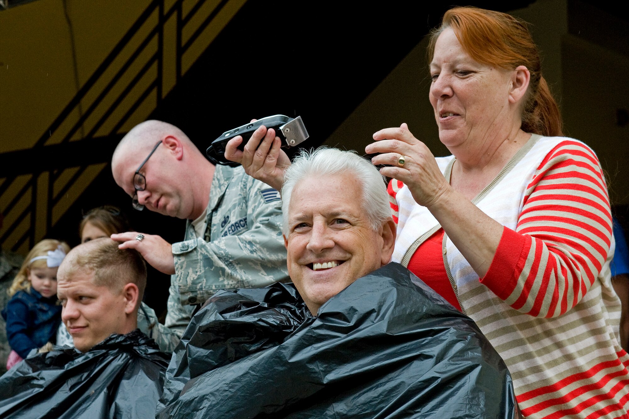 Volunteers from the 4th Security Forces Squadron have their heads shaved to raise money for a 4th SFS member’s family, May 2, 2014, at Seymour Johnson Air Force Base, N.C. An auction was held to determine who would get to shave each volunteers head. Proceeds were donated to a 4th SFS member who is facing an unexpected hardship. (U.S. Air Force photo/Airman 1st Class Aaron J. Jenne)