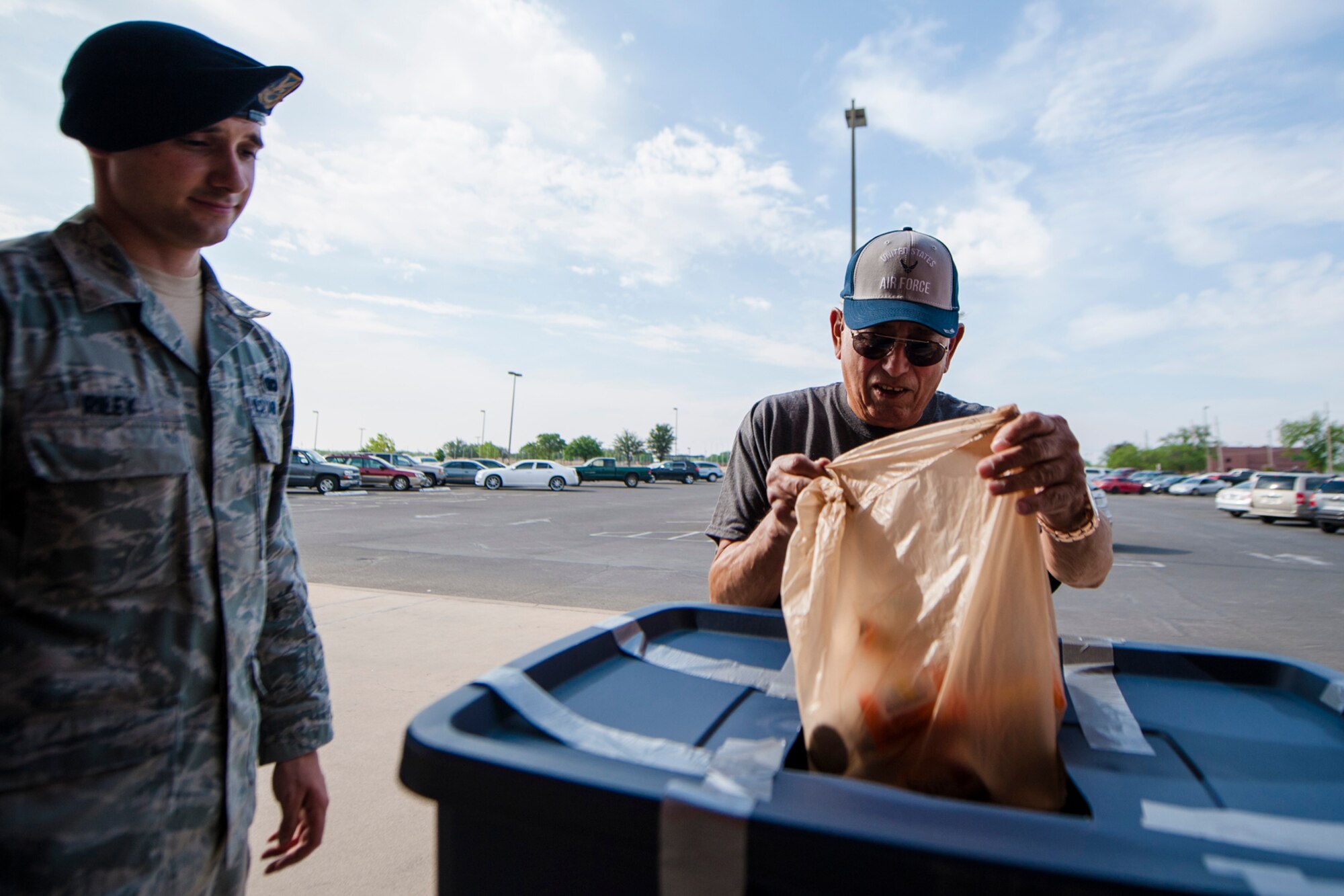 GOODFELLOW AIR FORCE BASE, Texas -- Senior Airman Mark A. Riley, 17th Security Forces Squadron patrolman, watches as Air Force retiree Jesus Cortinas, returns unused prescription drugs into the collection bin during the drug take back event in front of the Exchange April 26. The 17th SFS and 17th Medical Group work together twice a year to sponsor the event, which gives Team Goodfellow members a chance to dispose of unused drugs in a legal and environmentally conscious manner. (U.S. Air Force photo/ Senior Airman Michael Smith)