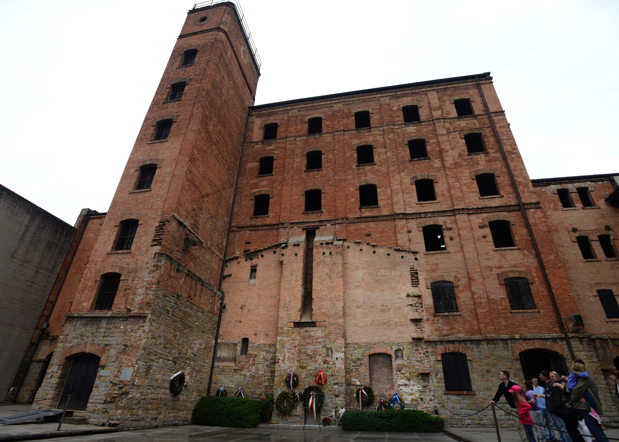 Team Aviano members stand in the courtyard of the Risiera di San Sabba concentration camp, May 3, 2014, in Trieste, Italy. Metal plates mark the site of the destroyed crematorium and the outline of the eastern wall of the crematorium is still visible on the main building. (U.S. Air Force photo/Airman 1st Class Deana Heitzman)
