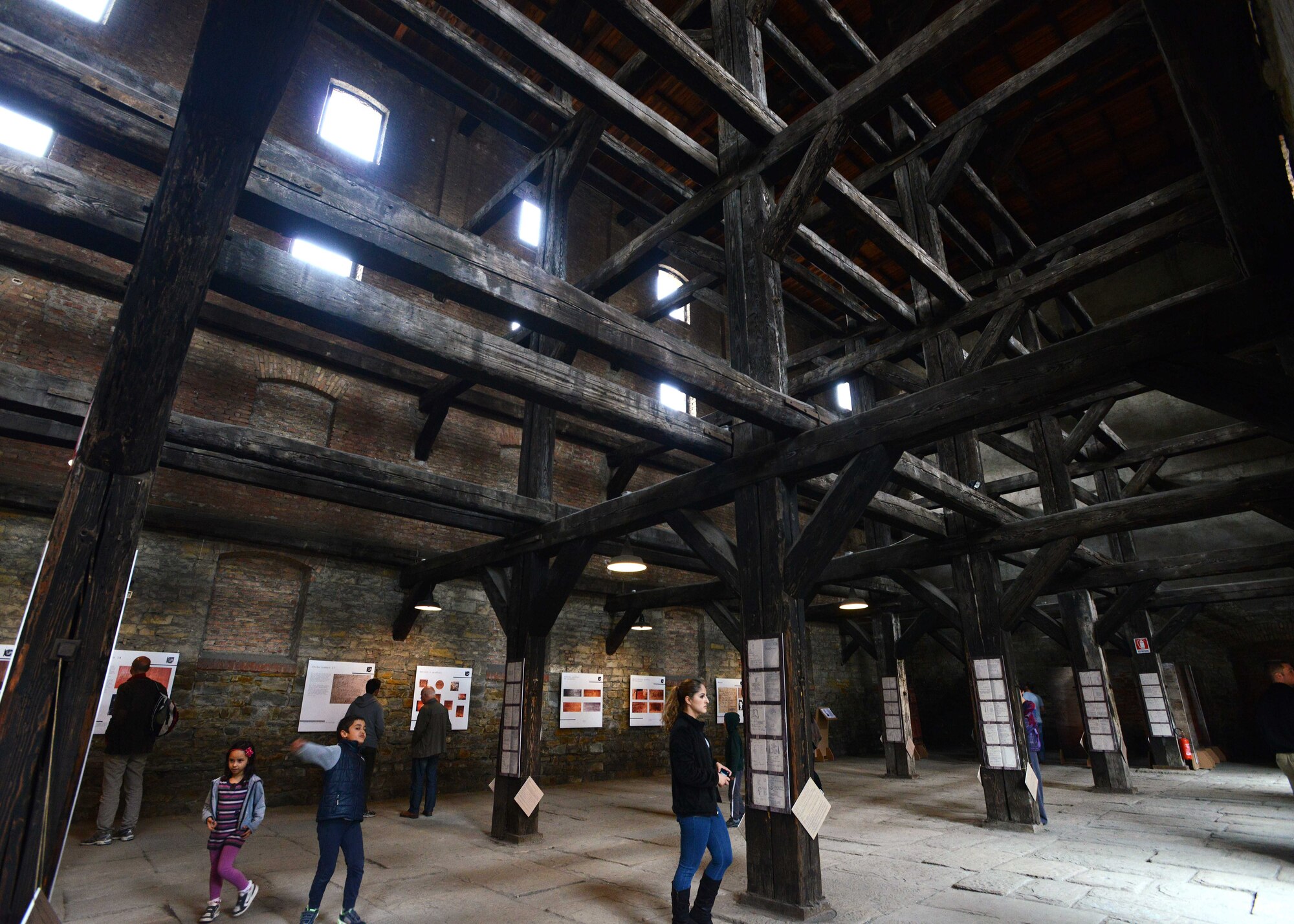 Team Aviano members read displays throughout “the room of crosses” in the Risiera di San Sabba concentration camp, May 3, 2014, in Trieste, Italy. The room was named for the large wooden beams that separated the floors and rooms.  (U.S. Air Force photo/Airman 1st Class Deana Heitzman)