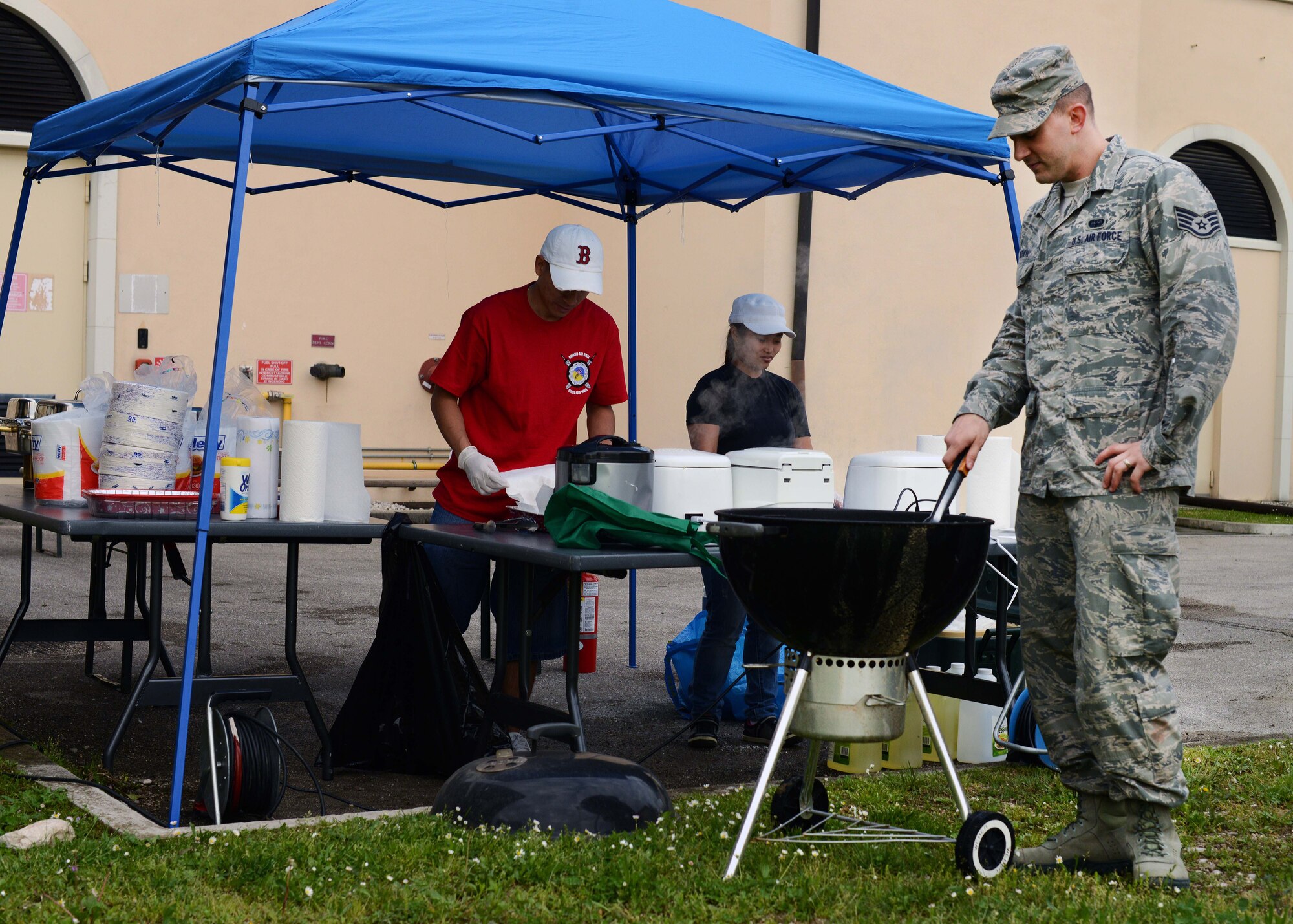 Staff Sgt. Christopher Sandahl, 31st Communication Squadron, grills during an Air Force Assistance Fund event, April 30, 2014, at Aviano Air Base, Italy. Practicing proper grilling techniques throughout the summer can help prevent the growth of bacteria foodborne illnesses from developing on food. (U.S. Air Force photo/Airman 1st Class Deana Heitzman)
