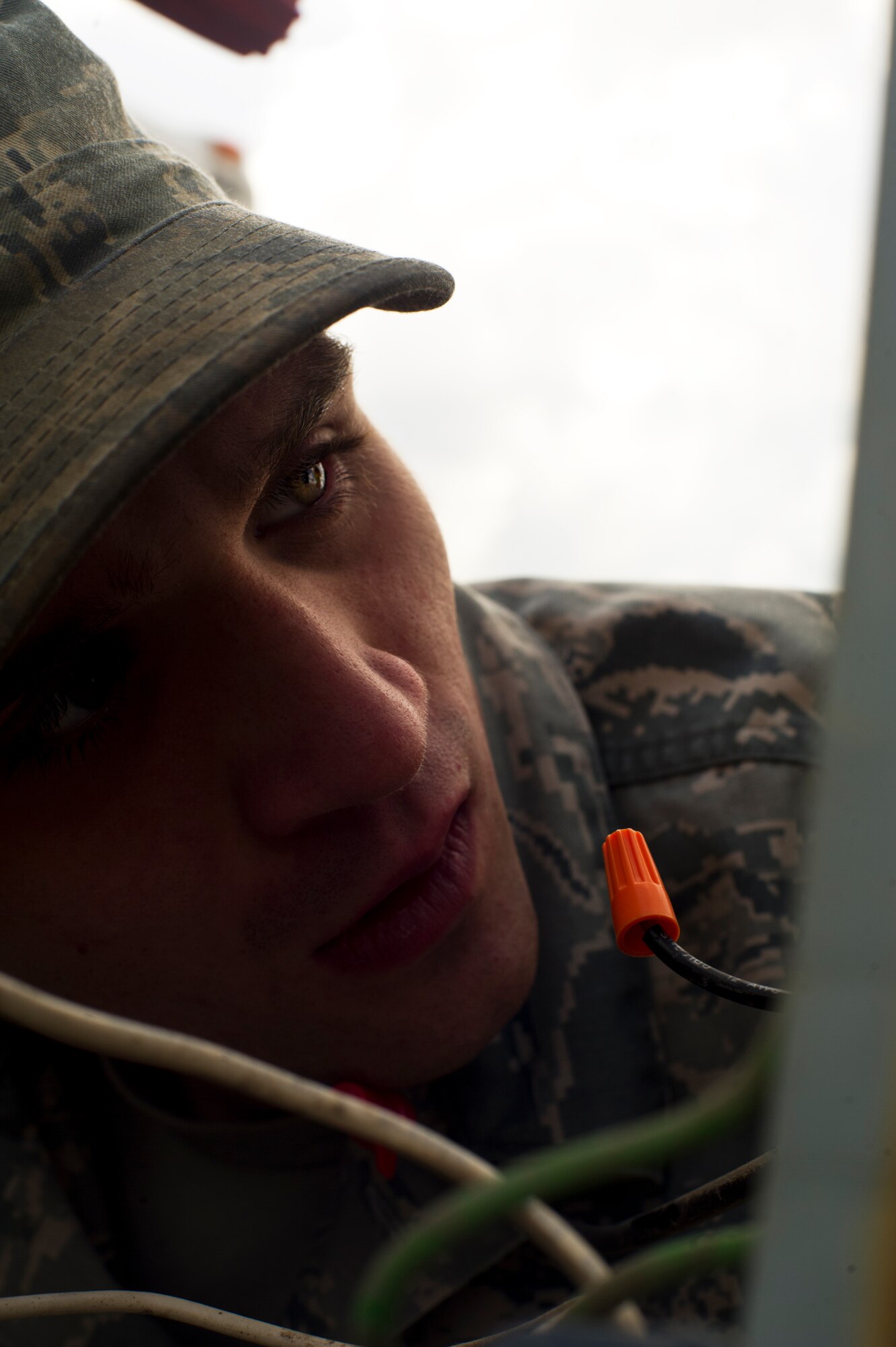 Airman Adam Fiktus, 5th Civil Engineer Squadron electrical systems apprentice, looks into an electrical outlet box at Minot Air Force Base, N.D., April 24, 2014. Electricity is a fundamental utility that allows command centers and Airmen to successfully fulfill their missions. Installing, repairing and maintaining this electrical network is the job of the electrical systems specialists. (U.S. Air Force photo/Senior Airman Brittany Y. Auld)