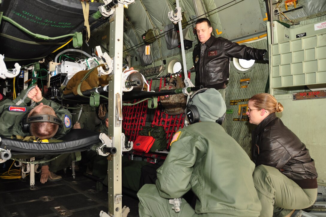 932nd Aeromedical Evacuation Squadron supervisor Maj. Bruce Schlager, a trained 932nd AES Flight Nurse, checks the status of a "patient" as crewmembers look on. Schlager served for thirty-two years, twenty-two of which were enlisted, and ten as an officer. Schlager had this to say about his last flight with the unit before retirement:   "I'm sad but happy, and ready to take the next step in life."  (U.S. Air Force Photo/ Staff Sgt. Amber Hodges) 
