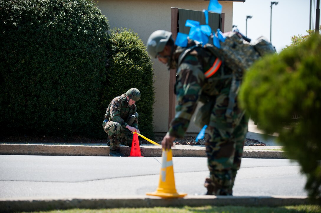 Senior Airman Trevis Stiles, 8th Force Support Squadron food service journeyman, left, and Senior Airmen Isiah Davis, 8th FSS fitness specialist, restrict access to debris following an explosion during exercise Beverly Bulldog 14-2 at Kunsan Air Base, Republic of Korea, May 6, 2014. Stiles and Davis are part of a post attack reconnaissance team and responsible for checking their area of responsibility after an attack. (U.S. Air Force photo by Staff Sgt. Clayton Lenhardt/Released)