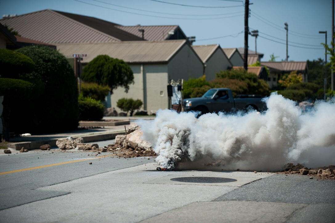 The 8th Fighter Wing Safety Office used smoke grenades to add realism during exercise Beverly Bulldog 14-2 at Kunsan Air Base, Republic of Korea, May 6, 2014. Smoke grenades are commonly used during exercises to simulate explosions and enemy fire. (U.S. Air Force photo by Staff Sgt. Clayton Lenhardt/Released)