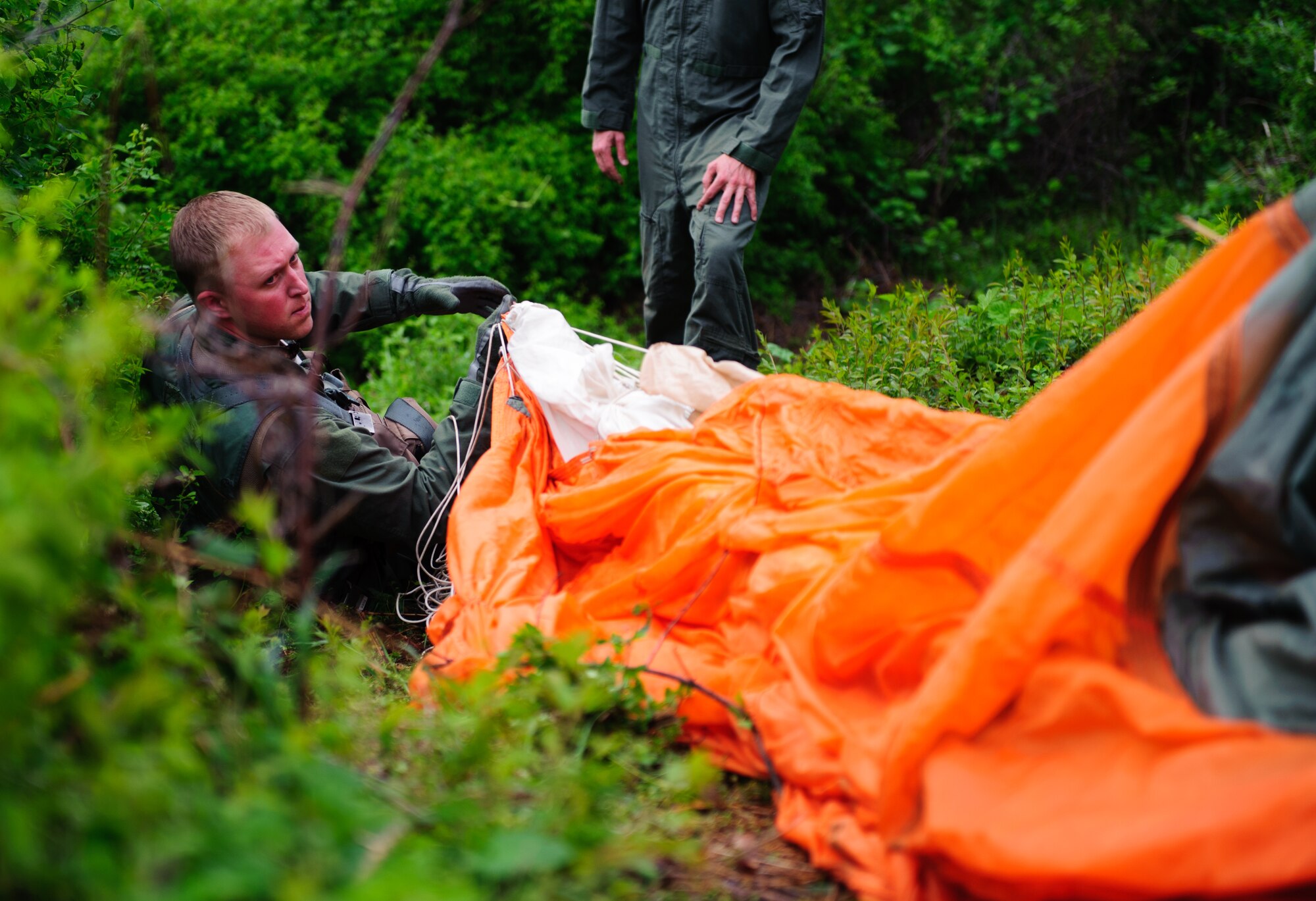 Maj. Aaron Johnson, 35th Fighter Squadron pilot, hauls his parachute in after “landing” and prepares to evade during his combat survival exercise near Kunsan Air Base, Republic of Korea, April 28, 2014. The Survival, Evasion, Resistance and Escape sections trained pilots on procedures to evade adversaries and return to friendly forces in case they need to eject. (U.S. Air Force photos by Senior Airman Armando A. Schiwer-Morales/Released)