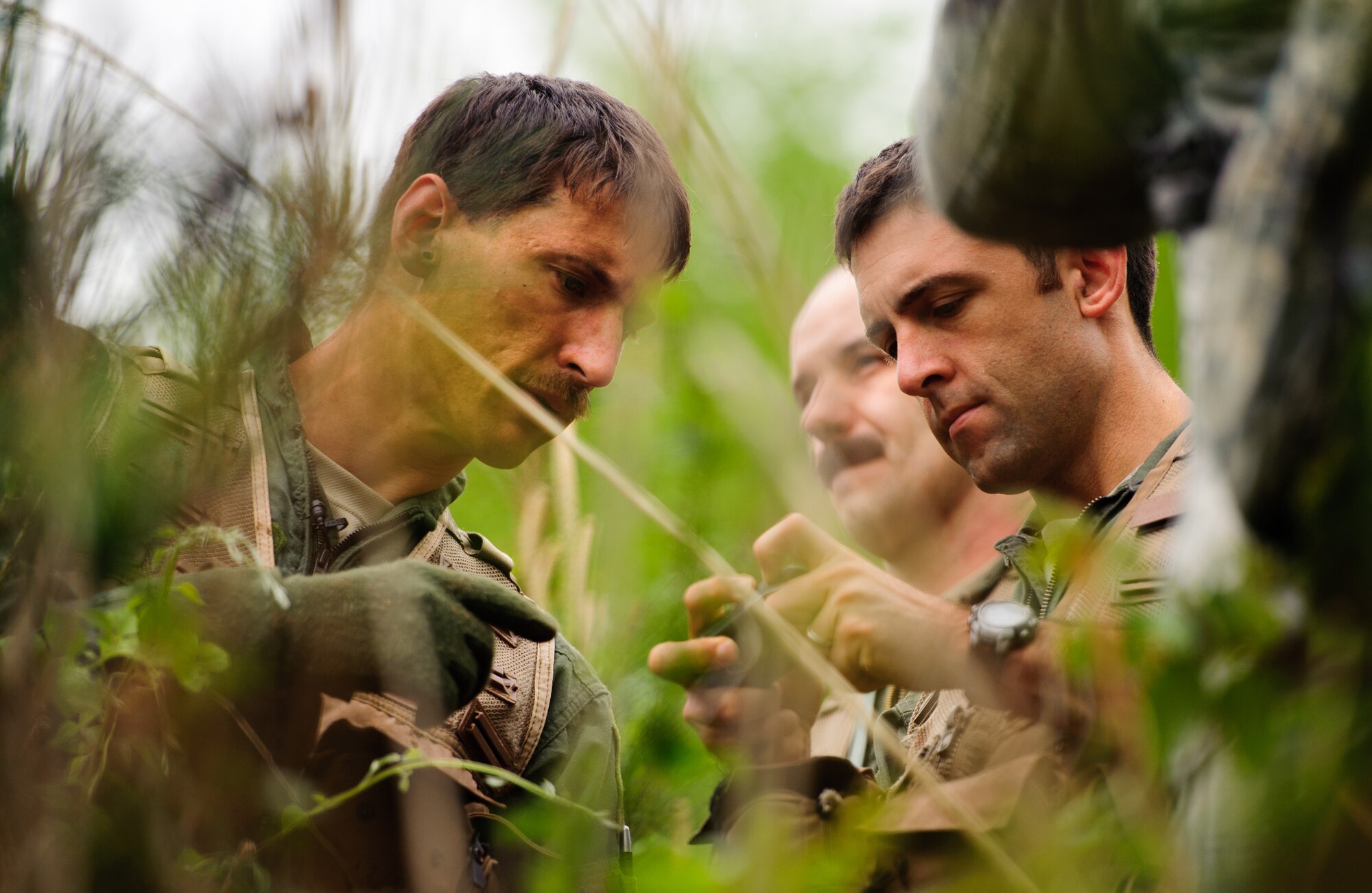 Tech. Sgt. Kurtis Douge, 8th Operations Support Squadron SERE specialist and weapons and tactics NCO in charge, shows Maj. Zach Manning, 35th Fighter Squadron pilot, how to use his global positioning system during a combat survival exercise near Kunsan Air Base, Republic of Korea, April 28, 2014. Douge and the Survival, Evasion, Resistance and Escape sections trained pilots on procedures to evade adversaries and return to friendly forces in case they need to eject. (U.S. Air Force photos by Senior Airman Armando A. Schiwer-Morales/Released)