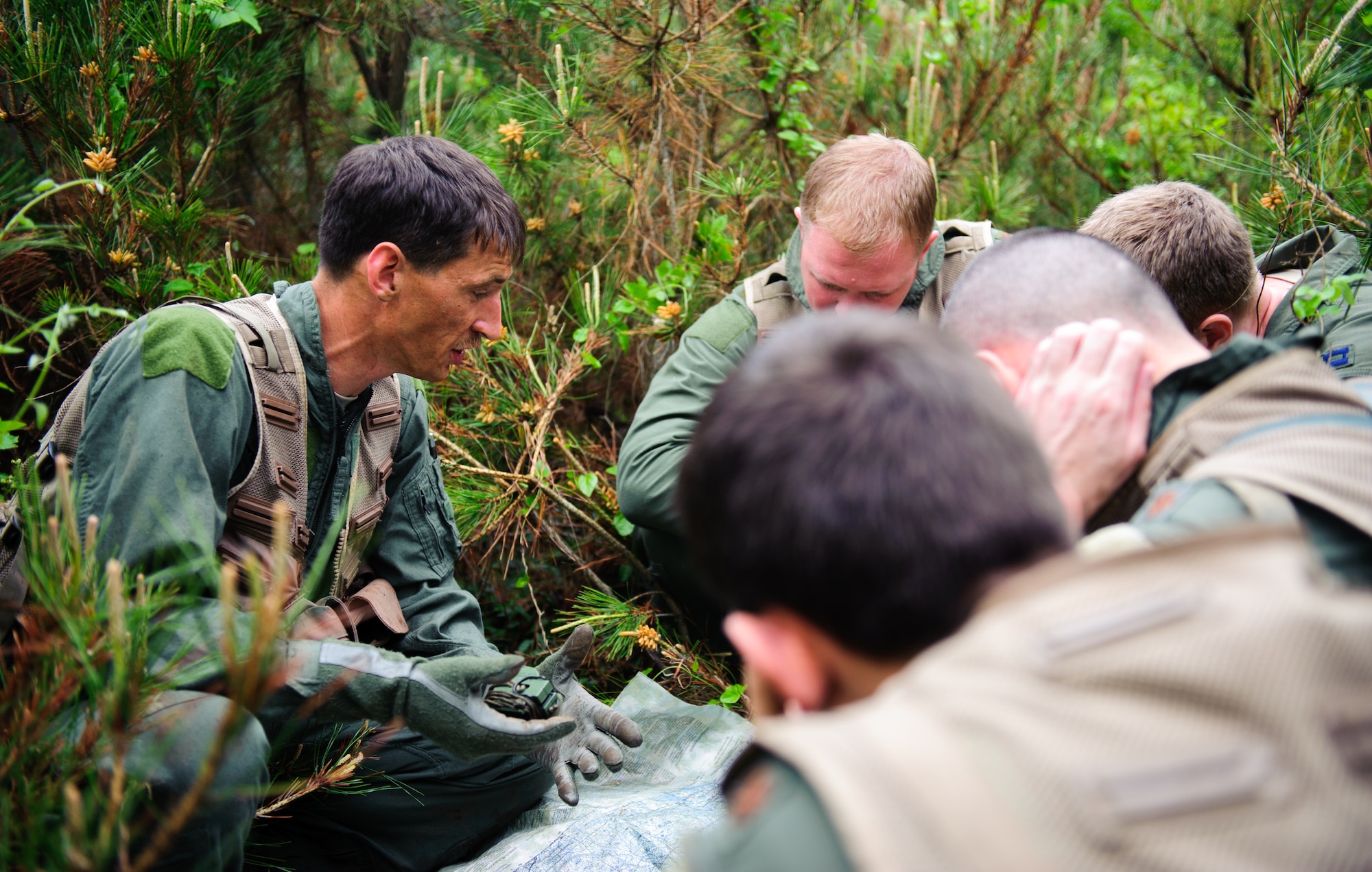 Tech. Sgt. Kurtis Douge, 8th Operations Support Squadron SERE specialist and weapons and tactics NCO in charge, shows navigation tactics to 35th Fighter Squadron pilots near Kunsan Air Base, Republic of Korea, April 28, 2014. Douge and the Survival, Evasion, Resistance and Escape sections trained pilots on procedures to evade adversaries and return to friendly forces in case they need to eject. (U.S. Air Force photos by Senior Airman Armando A. Schiwer-Morales/Released)