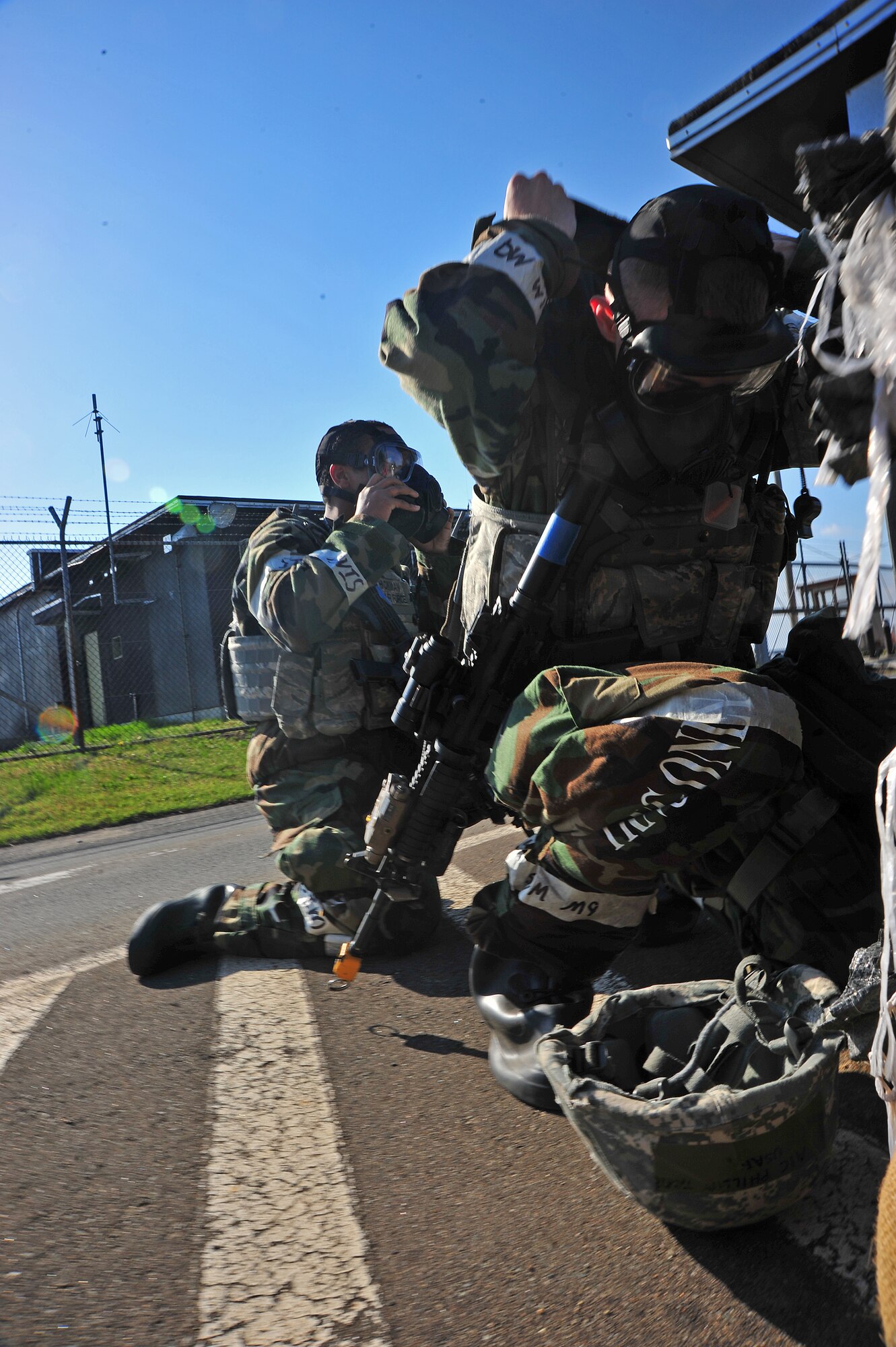 U.S. Air Force Airmen 1st Class Keyauntai Hickman and Tyler Phillips, 35th Security Forces Squadron entry controllers, secure their gas masks during an Operational Readiness Exercise at Misawa Air Base, Japan, May 6, 2014. During the ORE, Airmen are evaluated on their ability to don their gear and respond to an attack in a timely manner. (U.S. Air Force photo/Senior Airman Jose Hernandez-Domitilo)