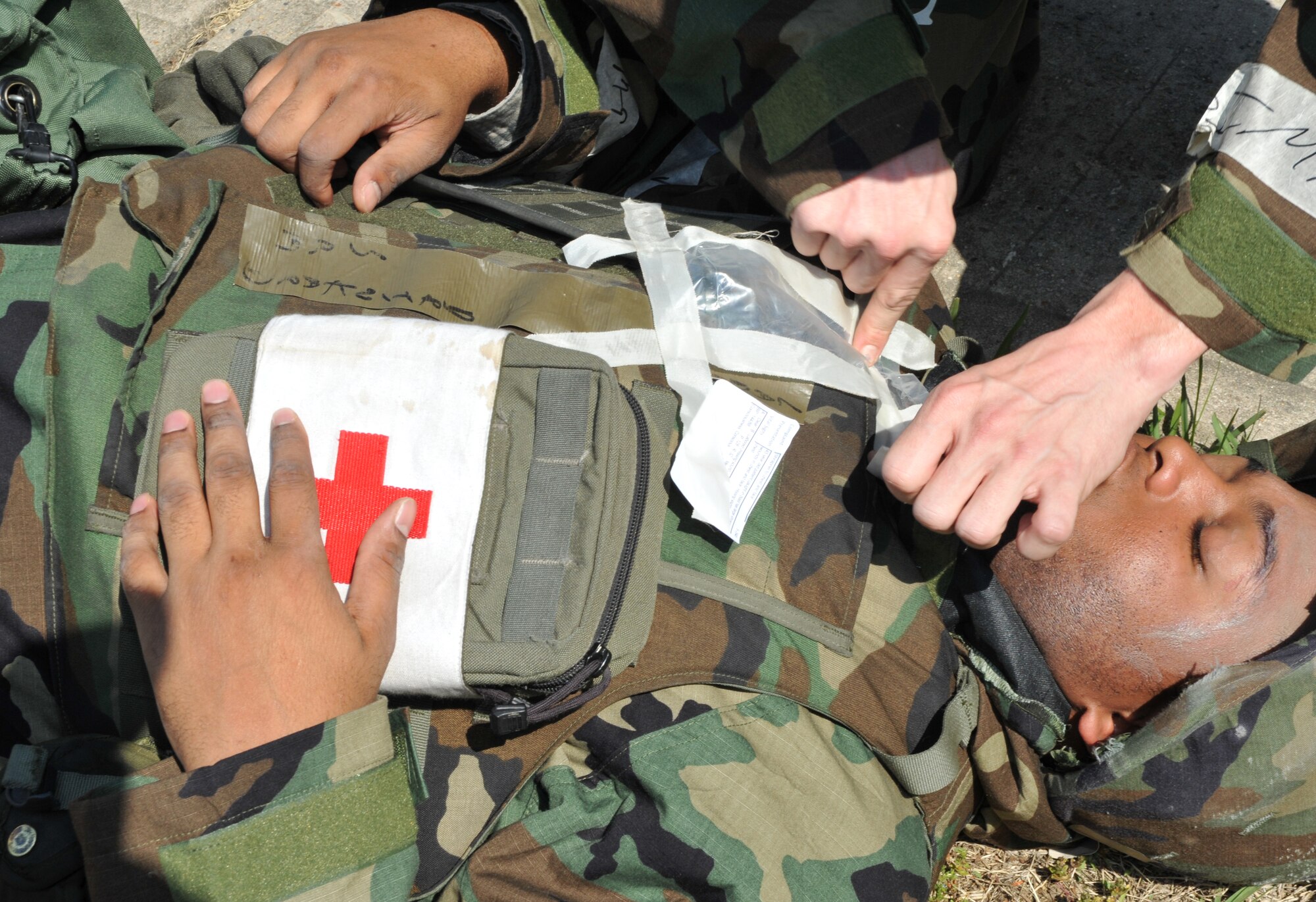 Senior Airman Byron Harrison, 51st Comptroller Squadron customer support technician, seals a mock sucking chest wound on a role player during Operational Readiness Exercise Beverly Bulldog 14-02 at Osan Air Base, Republic of Korea, May 6, 2014. The scenario saw role players portraying various maladies, including shock, burns and injuries to eyes and limbs. (U.S. Air Force photo/Airman 1st Class Ashley J. Thum)