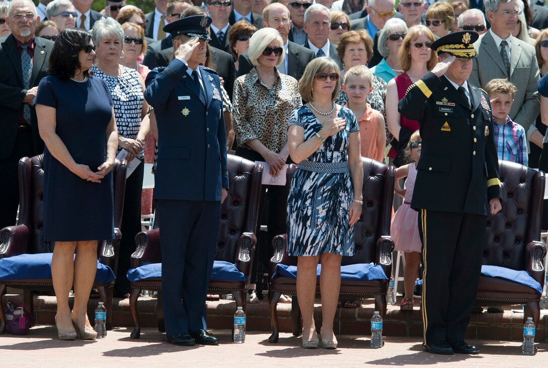 Army Gen. Martin E. Dempsey, right, chairman of the Joint Chiefs of Staff, his wife, Deanie, Gen. William M. Fraser III, outgoing commander of U.S. Transportation Command, and his wife, Beverly, render honors as the national anthem plays during the change-of-command ceremony on Scott Air Force Base, Ill., May 5, 2014.