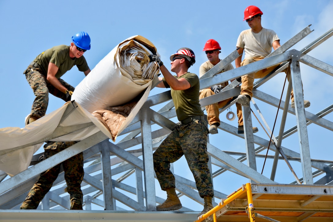 U.S. Air Force and Marine engineers insulate the roof at the Edward P. Yorke school during New Horizons 2014 in Belize City, Belize, April 18, 2014. U.S. Southern Command sponsored the exercise, during which civil engineers from the United States and Belize will construct three school additions in Belize City and one in Hattieville.  