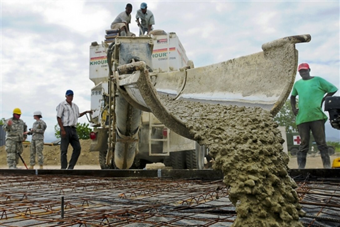 Civilian workers pour slurry for a school building's foundation during Beyond the Horizon 2014 in Barahona, Dominican Republic, April 22, 2014. The mission provides humanitarian assistance to Latin American countries, including medical care to local citizens at no cost, and building schools and medical clinics to improve the quality of life of the residents of the countries participating in the event.  