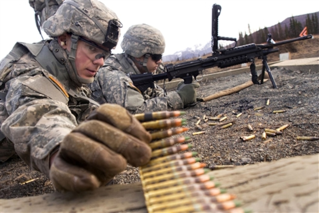 Army Pvt. Bryan Iratcabal, foreground, reaches for a linked belt of 5.56mm ammunition while Army Pfc. Victor Serrano waits to fire his M249 squad automatic weapon during training on Joint Base Elmendorf-Richardson, Alaska, April 23, 2014. Iratcabal and Serrano are assigned to the 23rd Engineer Company, 6th Engineer Battalion Combat, Airborne, 2nd Engineer Brigade, Alaska.  
