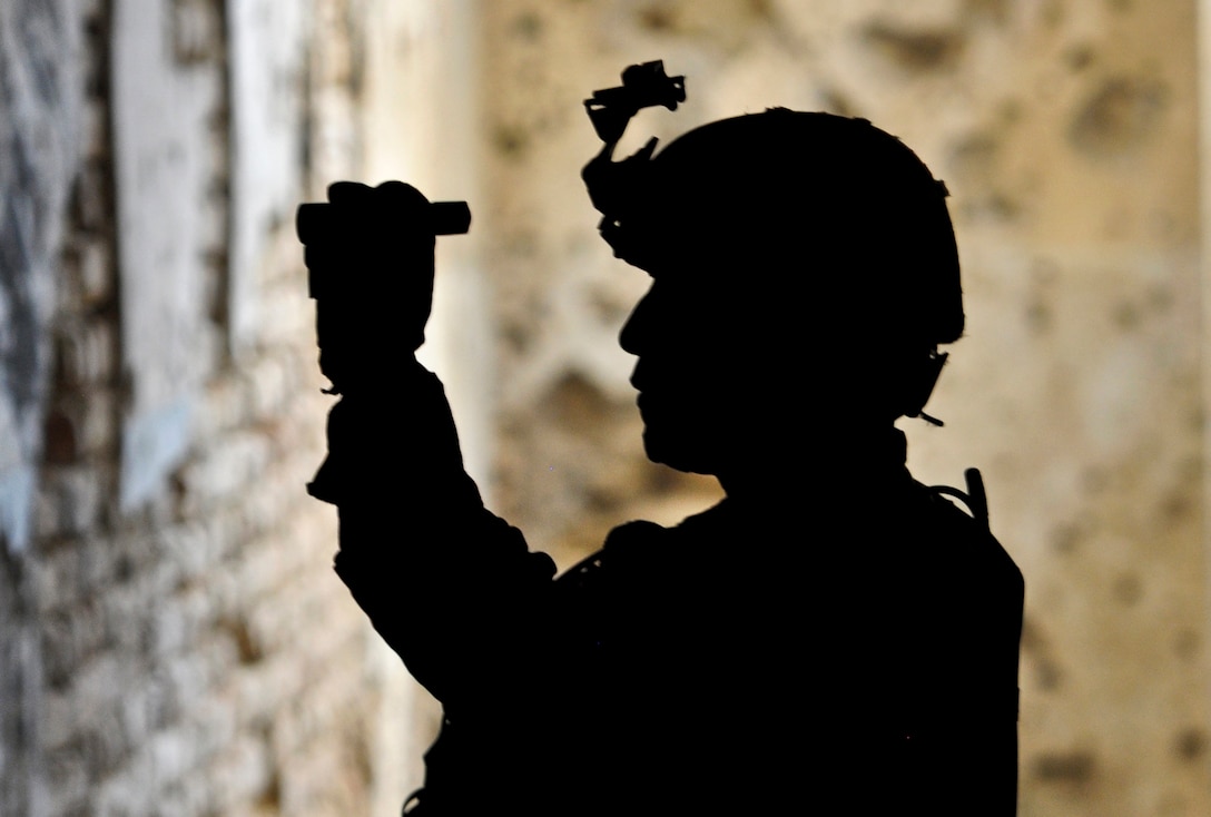 The silhouette of U.S. Army Staff Sgt. Clarence C. Elicio shows inside a tunnel at Qala-I-Jangi in northern Afghanistan's Balkh province, Sept. 30, 2013. Elicio is using a flashlight to observe another pathway. Elicio is the squad leader for Company A, 1st Battalion, 294th Infantry Regiment, Guam Army National Guard. 
