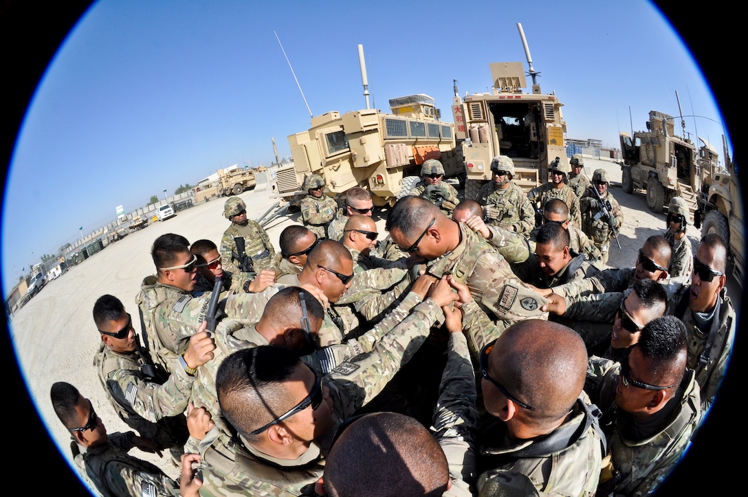 U.S. Army 1st Sgt. John C. Pangelinan, center, receives a pre-mission battle cry from his soldiers on Main Operating Base Lashkar Gah in Afghanistan's Helmand province in late September, 2013. Pangelinan is assigned to Company B, 1st Battalion, 294th Infantry Regiment, Guam Army National Guard.  
