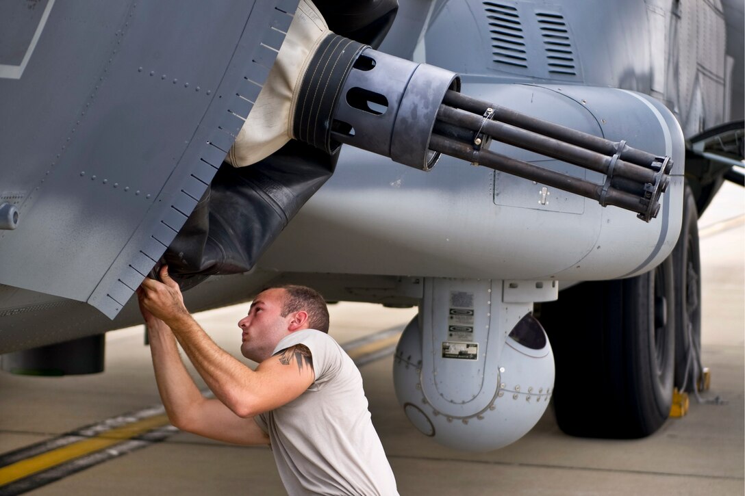 Air Force Staff Sgt. Johnathan Pierce adjusts a 25-mm Gatling gun on an aircraft for departure on Hurlburt Field, Fla., Oct. 3, 2013. The Air Force is relocating Hurlburt aircraft to prepare for developing Tropical Storm Karen. Pierce is a weapons load crew technician for 1st Special Operations Equipment Maintenance Squadron.  

