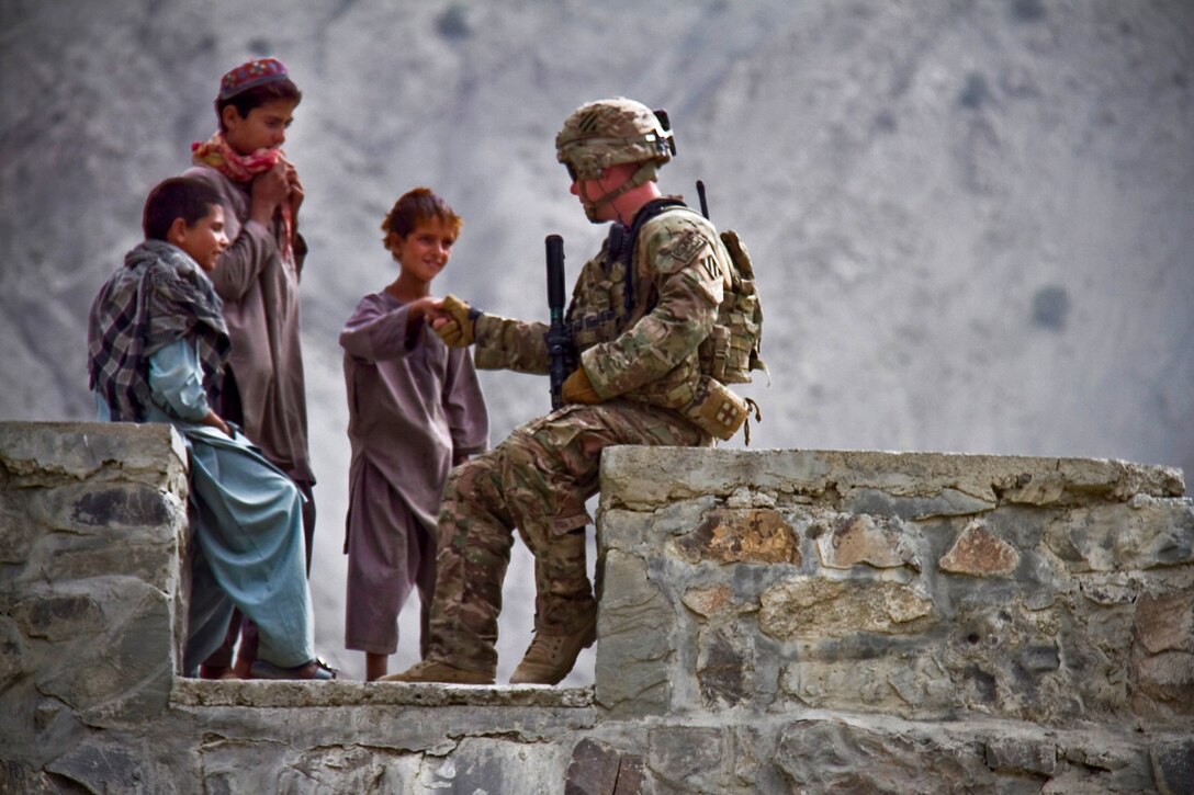 A U.S. soldier shakes hands with an Afghan boy while on a security mission in Paktya province, Afghanistan, Aug. 31, 2013. The soldier is assigned to the 101st Airborne Division's Company G, 1st Battalion, 506th Infantry Regiment, 4th Brigade Combat Team.  
