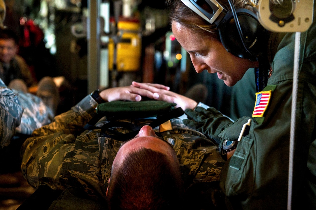 Air Force Reserve Maj. Kristina Spindel comforts a patient while flying in a WC-130J Hurricane Hunter aircraft during aeromedical evacuation training on Joint Base San Antonio-Lackland, Texas, Sept. 19, 2013. Spindel, a flight nurse, is assigned to the 433rd Aeromedical Evacuation Squadron.  
