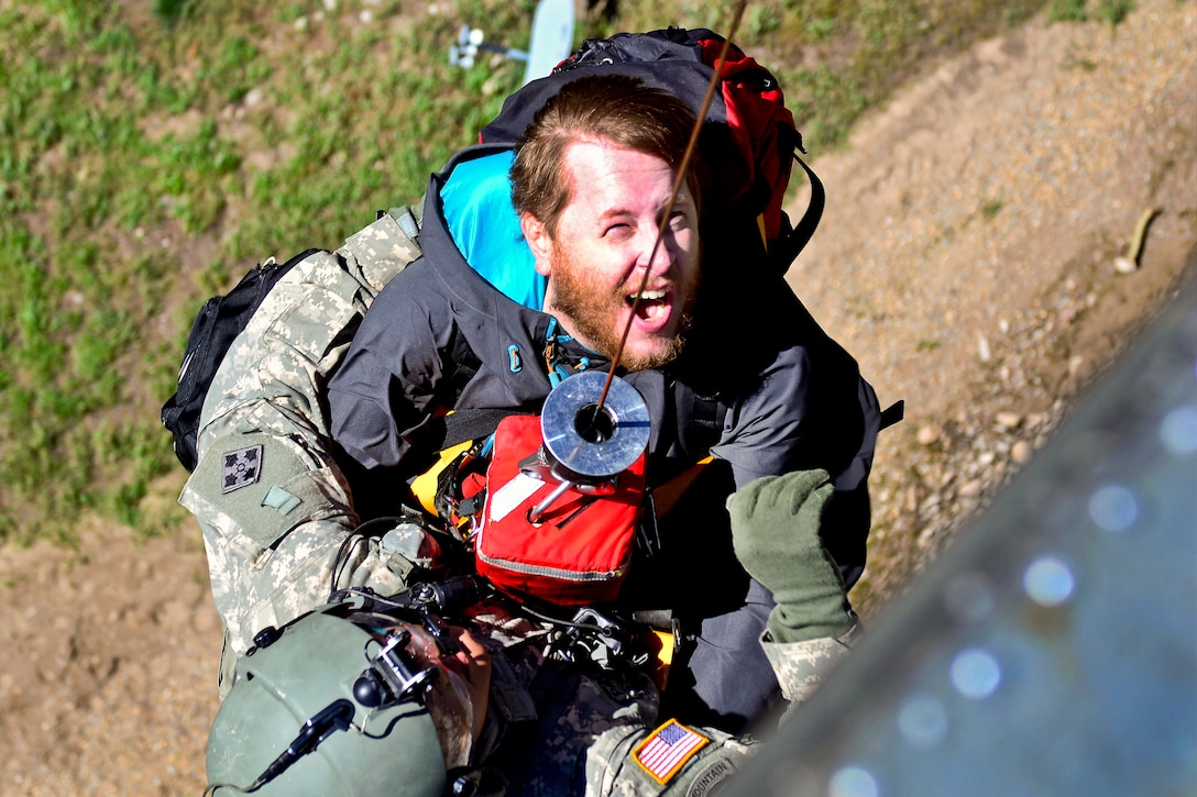 Army Staff Sgt. Jose Pantoja, left, carries Mike Daniels, an evacuee, up a hoist onto a UH-60 Black Hawk helicopter during rescue operations in Boulder, Colo., Sept. 16, 2013. Pantoja, a flight medic, is assigned to the 4th Infantry Division's Company C, 2nd General Support Aviation Battalion, 4th Combat Aviation Brigade.  
