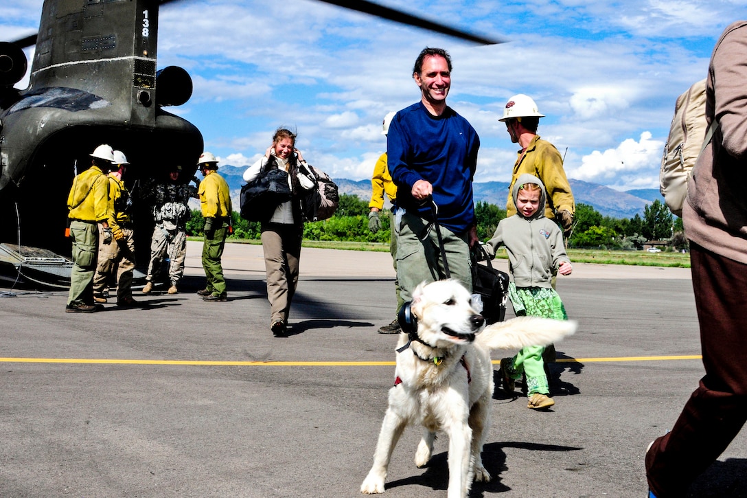 Soldiers and civilian rescue personnel transport residents and children from an outdoor education center in Jamestown, Colo., Sept. 14, 2013, after severe flooding shut down major roads leading out of the town. The soldiers are assigned to the 2nd Battalion, 4th Aviation Regiment in Fort Carson, Colo.  
