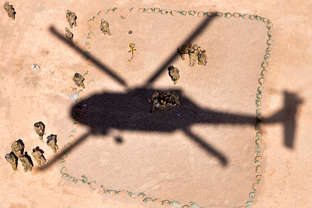 U.S. troops prepare for a UH-60 Black Hawk helicopter to hoist them up during hoist training on Forward Operating Base Farah, Afghanistan, Sept. 8, 2013. The troops are assigned to the 758th Forward Surgical Team, Provincial Reconstruction Team Farah, and the helicopter crew is assigned to Company C, 1st Battalion, 168th Aviation Regiment, General Support Aviation Battalion.  
