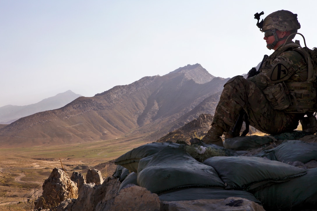 U.S. Army Pfc. Jordan Adams provides security from a hilltop during a meeting with Afghan national police in Bagram in Afghanistan's Parwan province, Sept. 7, 2013. Adams is assigned to the 1st Cavalry Division's 3rd Battalion, 82nd Field Artillery Regiment, 2nd Brigade Combat Team. The national police, one of the critical elements of Afghan national security forces, have assumed responsibility for security throughout Afghanistan.  
