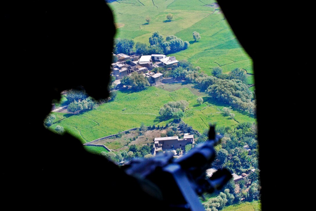 U.S. Army Sgt. Steve Lafond mans his machine gun inside a UH-60 Black Hawk helicopter over Jalalabad, Afghanistan, Sept. 10, 2013. Lafond, a crew chief, is assigned to the 3rd Battalion General Support, 10th Combat Aviation Brigade.  
