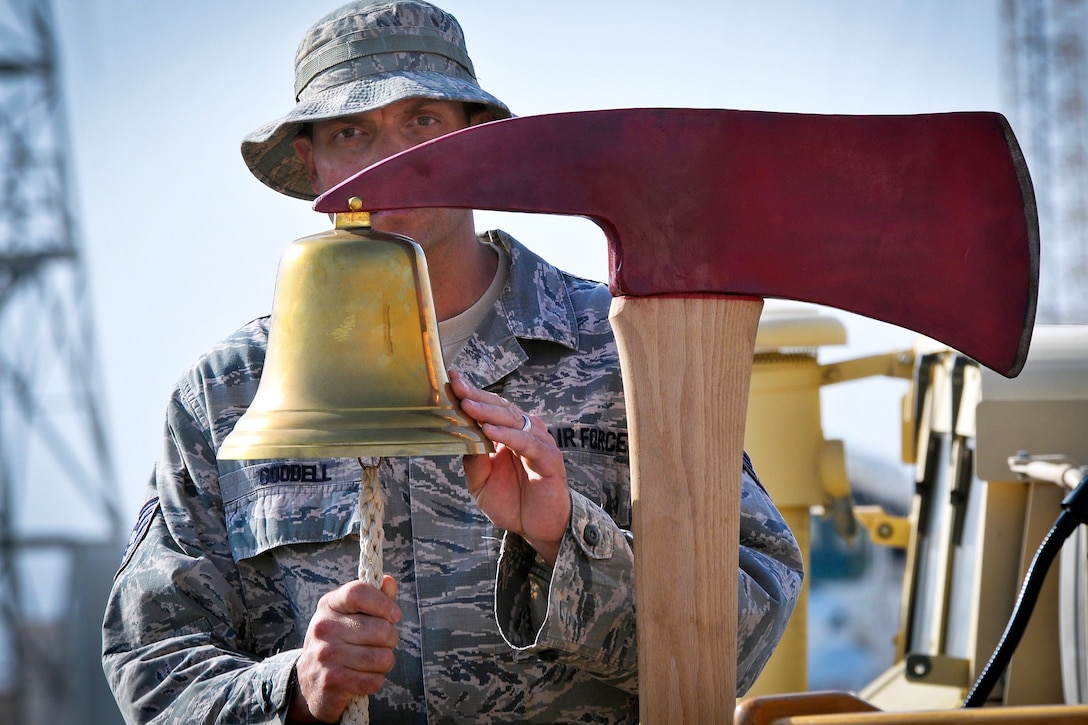 U.S. Air Force Staff Sgt. Steven Goodell rings a bell nine times in memory and tribute to the fallen firefighters of the 9/11 terrorist attacks during a commemoration ceremony at the 386th Air Expeditionary Wing in Southwest Asia, Sept. 11, 2013. Goodell, a firefighter, is assigned to the 386thAir Expeditionary Wing.  
