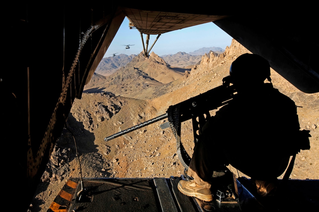 U.S. Marine Corps Gunnery Sgt. Marcus S. McCollum provides aerial security with a GAU-21 .50-caliber machine gun inside a CH-53E Super Stallion helicopter over Helmand province, Afghanistan, Aug. 22, 2013. McCollum, a crew chief, is assigned to Marine Heavy Helicopter Squadron 462.  
