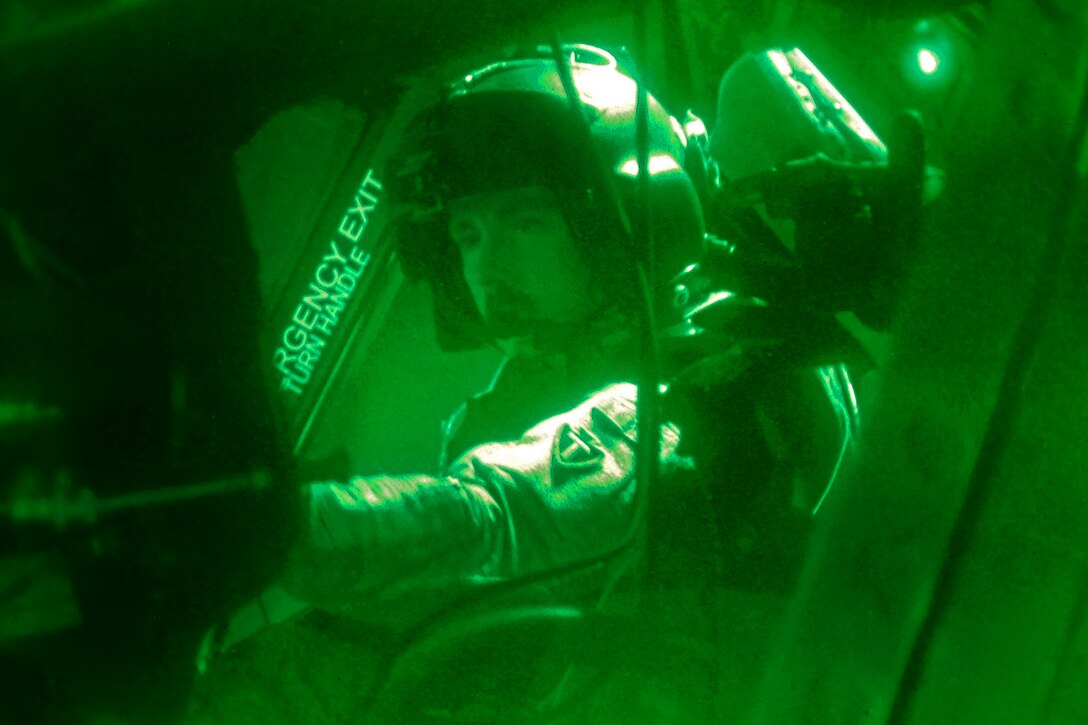 As seen through a night-vision device, U.S. Army Chief Warrant Officer 4 Robert Cudd prepares his equipment before a personnel and equipment movement mission on Bagram Airfield, Afghanistan, Aug. 31, 2013. Cudd, a pilot, is assigned to Company B, 2nd Battalion General Support, 36th Combat Aviation Brigade. 