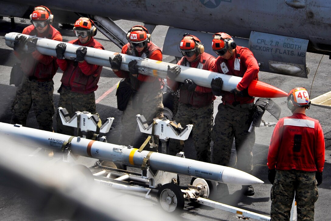 U.S. sailors lift a missile on the flight deck of the aircraft carrier USS Nimitz in the U.S. 5th Fleet area of responsibility, Aug. 31, 2013. The sailors, ordnancemen, are assigned to Marine Fighter Attack Squadron 323 
