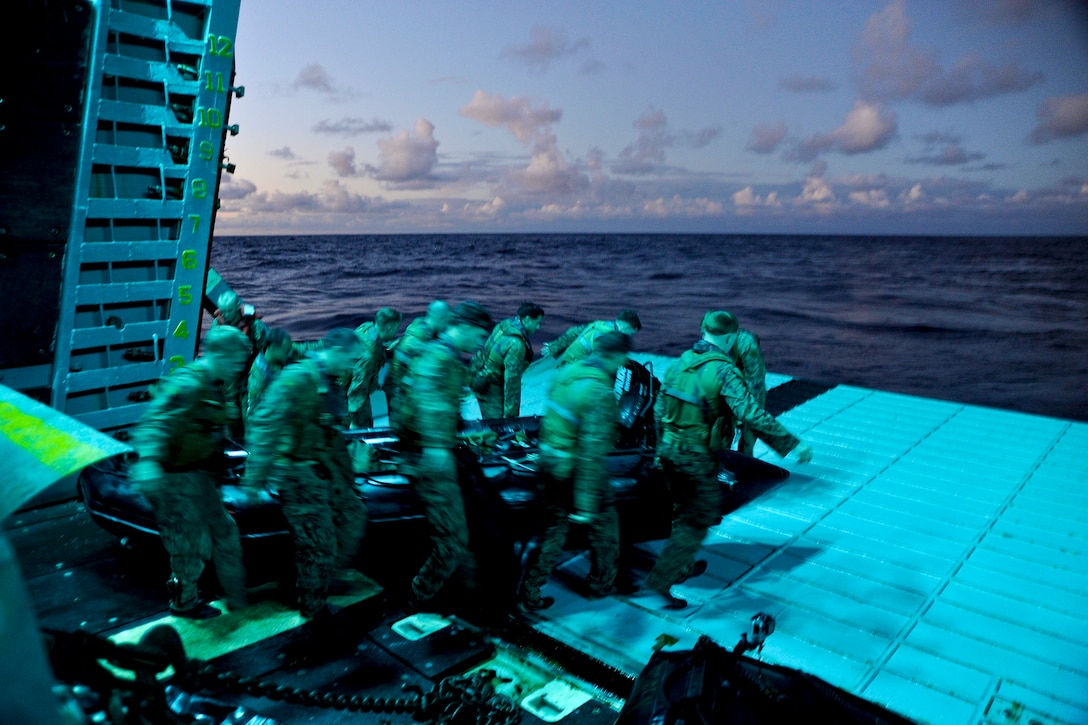 U.S. Marines move a combat rubber raiding craft into position as they prepare to depart from the stern gate of the amphibious assault ship USS Boxer in the Pacific Ocean, Aug. 30, 2013. The Boxer is part of the Boxer Amphibious Ready Group and the Marines are assigned to the 13th Marine Expeditionary Unit.  
