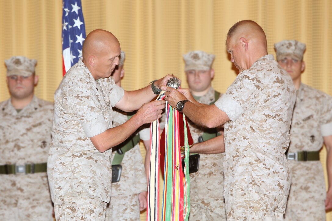 Lieutenant Gen. Robert Neller and Sgt. Maj. Lawrence Fineran, commander and
sergeant major of U.S. Marine Corps Central
Command, affix the Meritorious Unit Commendation streamer to the MARCENT
Battle Colors during an awards ceremony at the base theatre aboard
MacDill Air Force Base, May 6.  MARCENT received the unit award from the
Commandant of the Marine Corps for exceptionally meritorious service during
assigned missions from January 2010 to December 2011 in support of national
security objectives in the U.S. Central Command area of responsibility. 
Notable guests at the ceremony were Gen. John Paxton, Assistant Commandant
of the Marine Corps, and Brig. Gen. John Jansen, Assistant Deputy Commandant
for Programs
and Resources.
