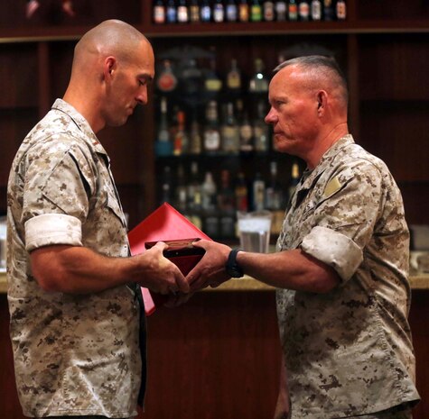 Major Gen. Lawrence D. Nicholson, right, the commanding general of 1st Marine Division, awards Chief Warrant Officer 2 Paul Klug, left, the motor transport maintenance officer with Truck Company, Headquarters Battalion, 1st Marine Division, the Marine Corps 2013 Motor Transportation Association’s Maintenance Officer of the Year award during an award ceremony aboard Marine Corps Base Camp Pendleton, Calif., April 30, 2014. Klug, a 40-year-old native of Oshkosh, Mo., earned the award for his leadership which helped the unit maintain a high level of readiness to respond to any crisis.