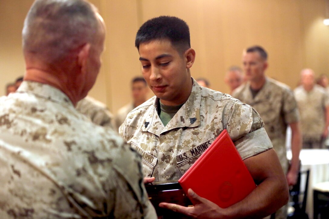 Major Gen. Lawrence D. Nicholson, left, the commanding general of 1st Marine Division, awards Cpl. Eduardo Navarro, a motor transport mechanic with 3rd Combat Engineer Battalion, the Marine Corps 2013 Motor Transportation Association’s Mechanic of the Year award during an award ceremony aboard Marine Corps Base Camp Pendleton, Calif., April 30, 2014. The 22-year-old native of El Paso, Texas, was awarded for several of his accomplishments, including seven missions he conducted in Afghanistan. Navarro was in charge of traveling 850 miles through hostile territory and he ensured every Marine and all the gear arrived at their destination.