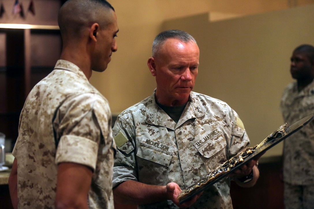 Major Gen. Lawrence D. Nicholson, the commanding general of 1st Marine Division, awards Capt. Frank Robinson, the commanding officer of Truck Company, Headquarters Battalion, 1st Marine Division, the Marine Corps 2013 Motor Transportation Association’s Unit of the Year award during an award ceremony aboard Marine Corps Base Camp Pendleton, Calif., April 30, 2014. Truck Co., earned the Motor Transport Unit of the Year award for demonstrating exceptional technical and tactical proficiency and dependability.