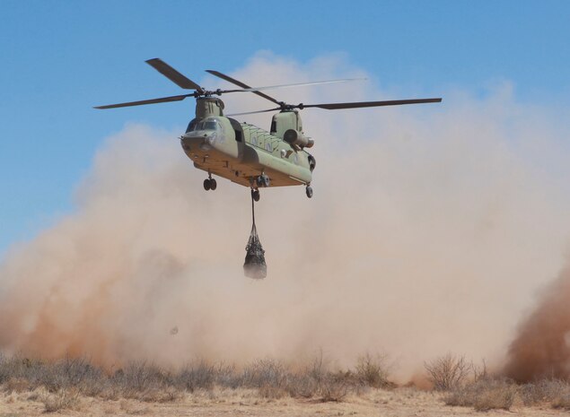 A CH-47 Chinook, with the 1st Battalion, -501st Aviation Regiment, 1st Armored Division, 2nd Brigade Combat Team picks up 1,000 pounds of tires during a training exercise with 2nd Combat Logistics Regiment at the Dona Anna training area on Fort Bliss, Texas, April 7, 2014. The Army air unit and Marines performed a total of five lifts; one with a Humvee and four with the tires. The Humvee was a simple elevator lift, picking the cargo straight up and setting it down and the tires were flown in a pattern around the training area.