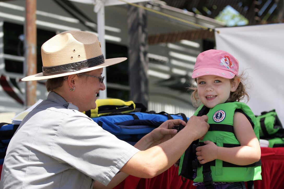 Amber Machado, a ranger at Black Butte Lake, the U.S. Army Corps of Engineers Sacramento District park near Orland, Calif., presents an eager young visitor with her new life jacket during the 2013 Life Jacket Trade-in event. 