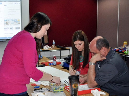 From left to right, Lauren Hopper, Ashley Krisman, and Chris Kerns, all teachers at Heritage High School, work on calculations for the Forensics and Discovery Math 2 module during a workshop at CERL in March. 