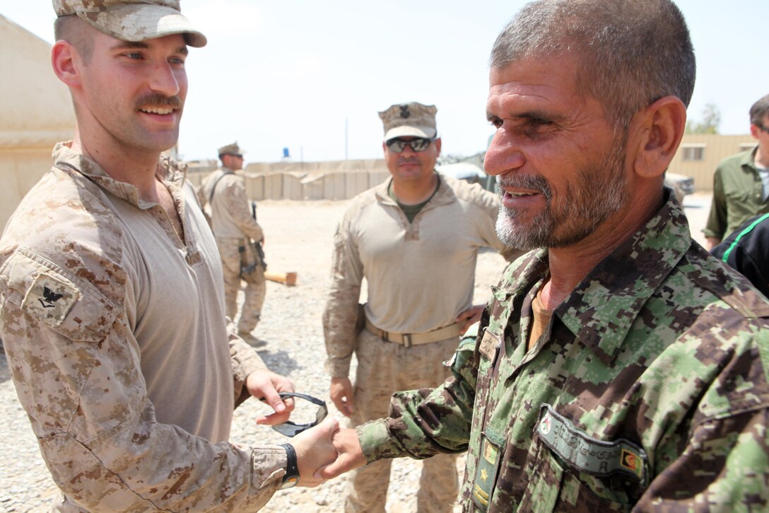 Petty Officer 3rd Class Kristopher Krysa, from La Grange Park, Illinois, and a corpsman with Security Force Assistance Adviser Team 2-215, says goodbye to an Afghan National Army medic with 2nd Brigade, 215th Corps, aboard Forward Operating Base Nolay, Helmand province, Afghanistan, May 2, 2014. Krysa and the other SFAAT 2-215 built strong working relationships and friendships with their ANA counterparts.