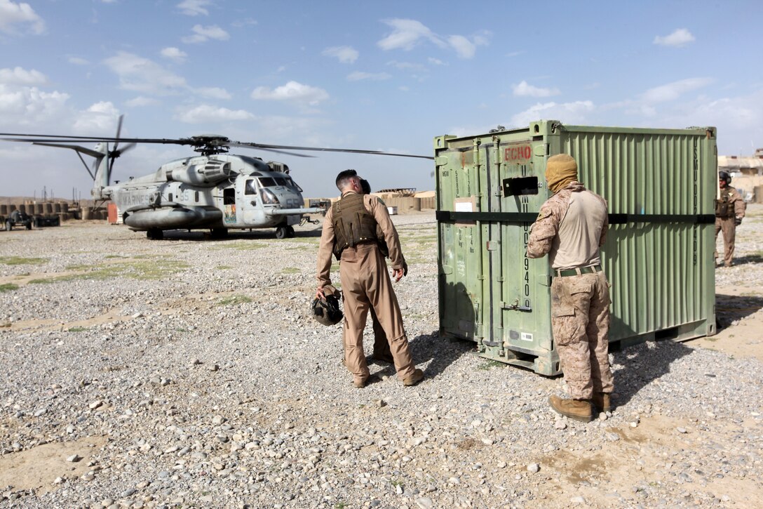 Maj. Michael Smith, center, operations officer and CH-53E Super Stallion pilot with Marine Heavy Marine Squadron 466, inspects a shipping container he and his crew are preparing to lift out of Forward Operating Base Sabit Qadam in the Sangin Valley of Helmand province, Afghanistan, May 3, 2014. The last Marines, sailors and equipment exited FOBs Nolay and Sabit Qadam, May 5, 2014, leaving the 2nd Brigade, 215th Corps, Afghan National Army in full control of the FOBs and the surrounding area for the first time without advisers in place since coalition forces entered during 2006. (U.S. Marine Corps Photo By: Sgt. Frances Johnson/Released)