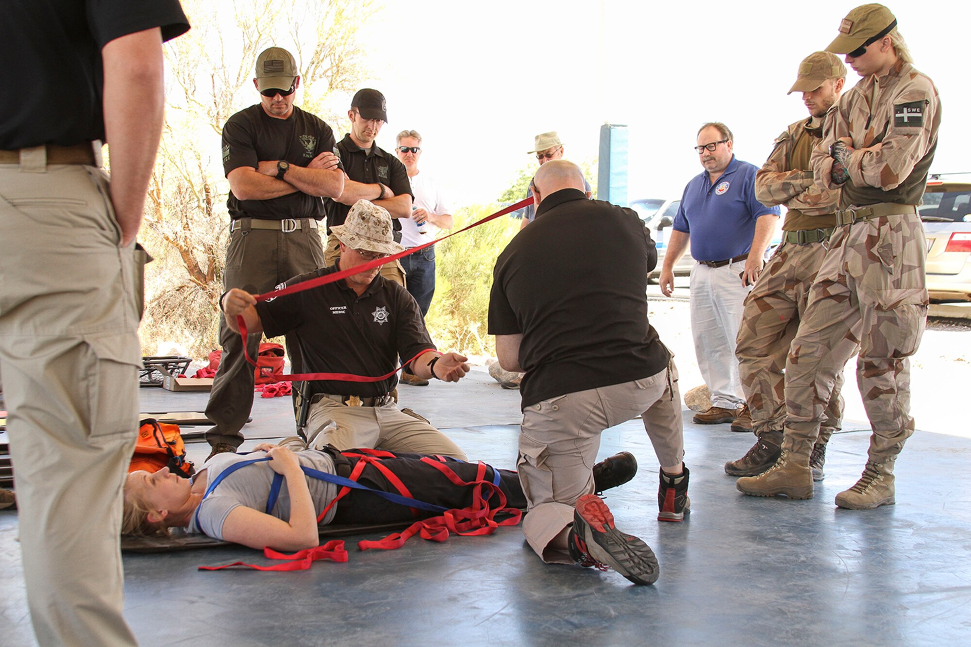 Members from the U.S. Secret Service, Swedish Air Force, Air Evacuation Services, and local police departments practice securing an injured person to a litter during Tactical Combat Casualty Care training at the Pima County Training Center in Tucson, Ariz., May 6, 2014. TCCC introduces evidence-based, life-saving techniques and strategies for providing the best trauma care on the battlefield.  TCCC is a training event held during Exercise ANGEL THUNDER.  Exercise ANGEL THUNDER is a joint-interagency-coalition annual exercise that supports DoD’s training requirements for Personnel Recovery responsibilities through high–fidelity exercises. Exercise ANGEL THUNDER provides the most realistic PR training environment available to USAF Rescue forces, as well as their Joint, Interagency, and Coalition partners. (U.S. Air Force photo by Tech. Sgt. Heather R.Redman/Released)